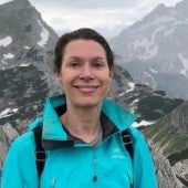 a smiling picture of Elizabeth Brake, with mountains in the background