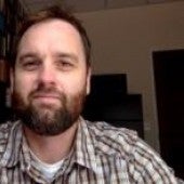 a simple headshot of Brian Miller with a bookcase in the background